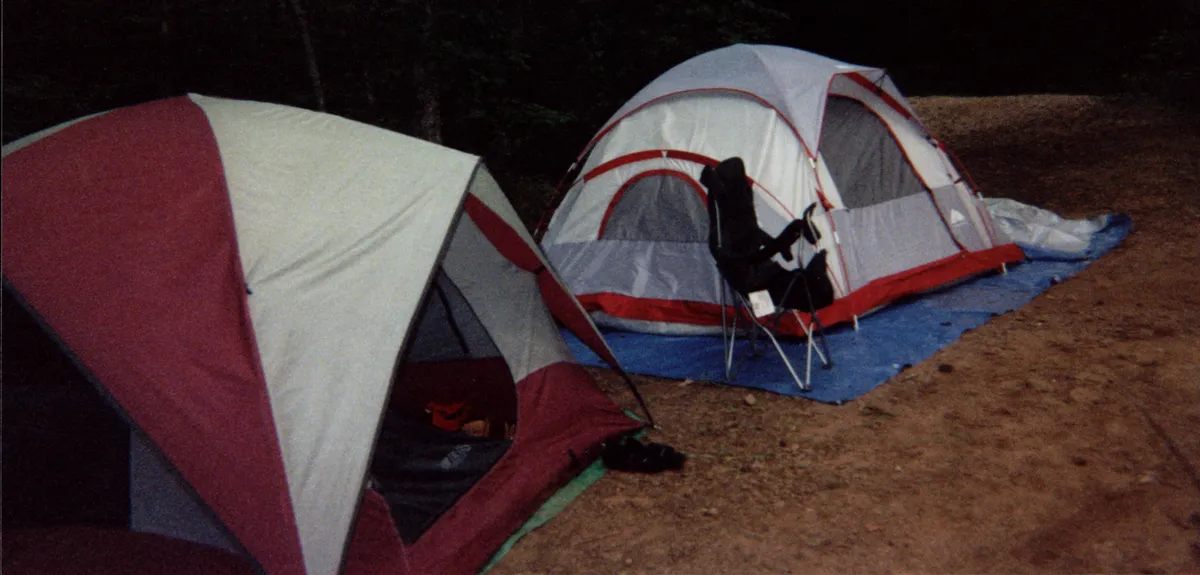 Several dome tents pitched together at a group campsite