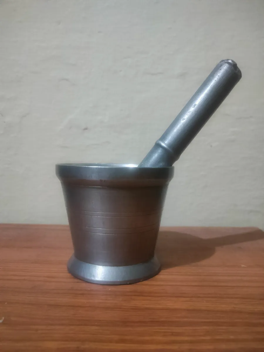 A stone mortar and pestle kept on a kitchen counter for daily use