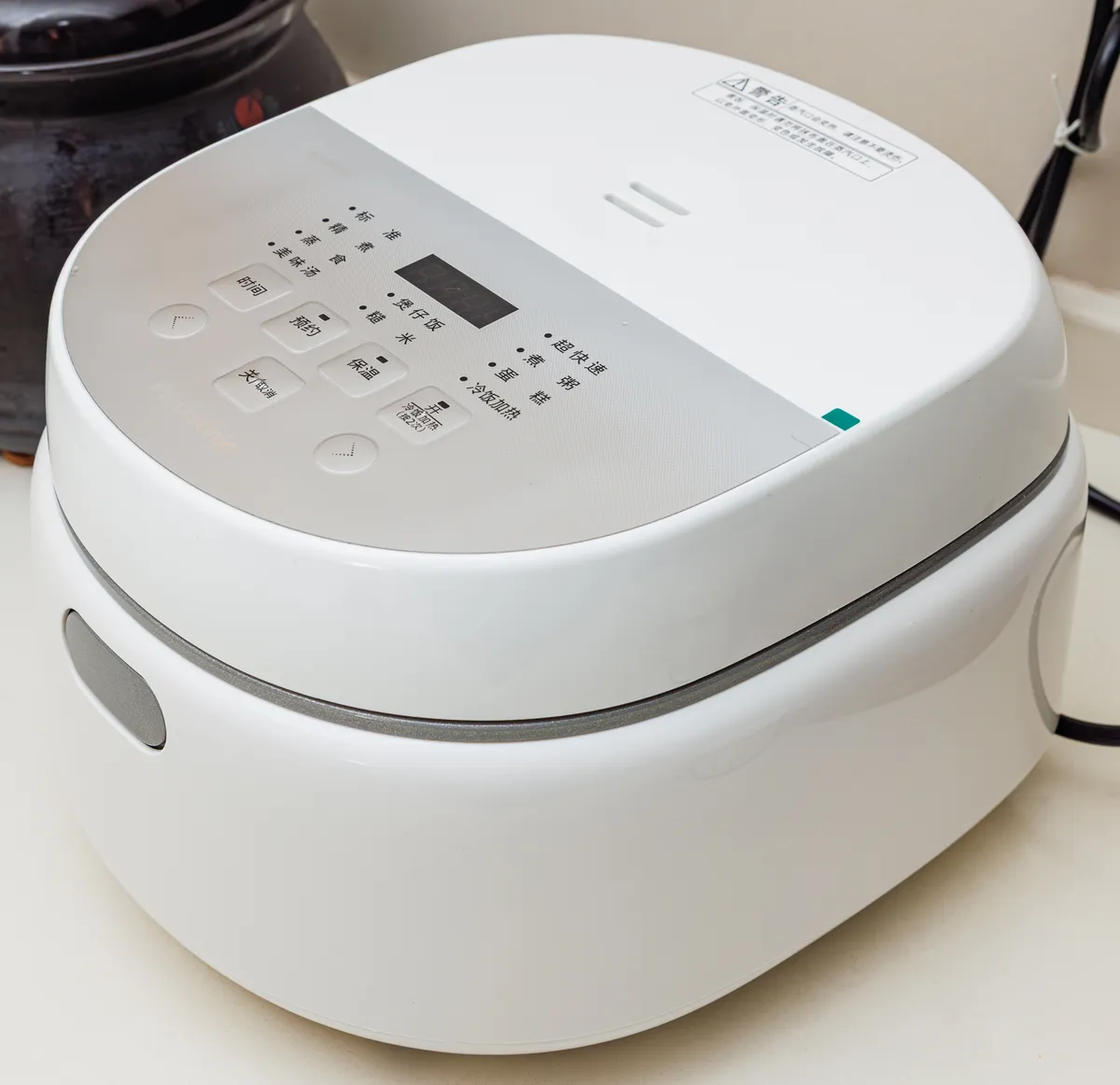 A comparable Japanese-market electric rice cooker with a hinged lid and control panel