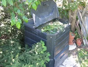 An open-topped compost bin with material at various stages of decomposition