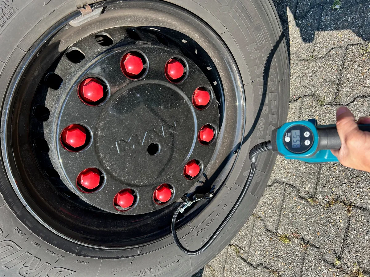 A pressure gauge being pressed onto a tyre valve