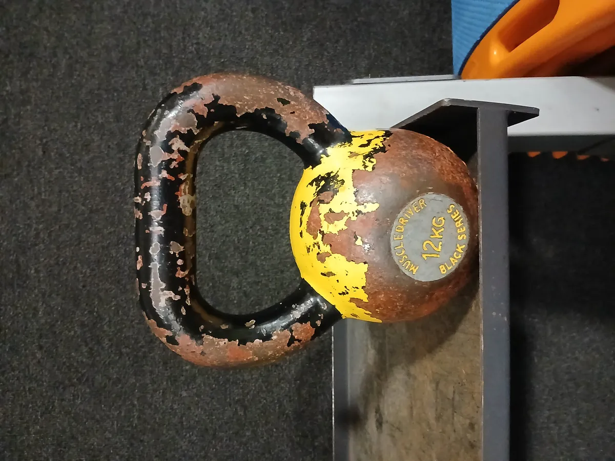 A cast iron kettlebell on a gym floor