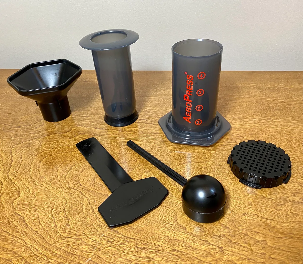 AeroPress with its stirrer, scoop, funnel and filter holder accessories