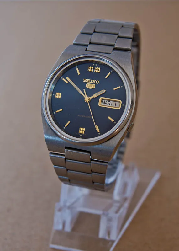 A Seiko 5 automatic on a steel bracelet, showing typical case finishing at this price