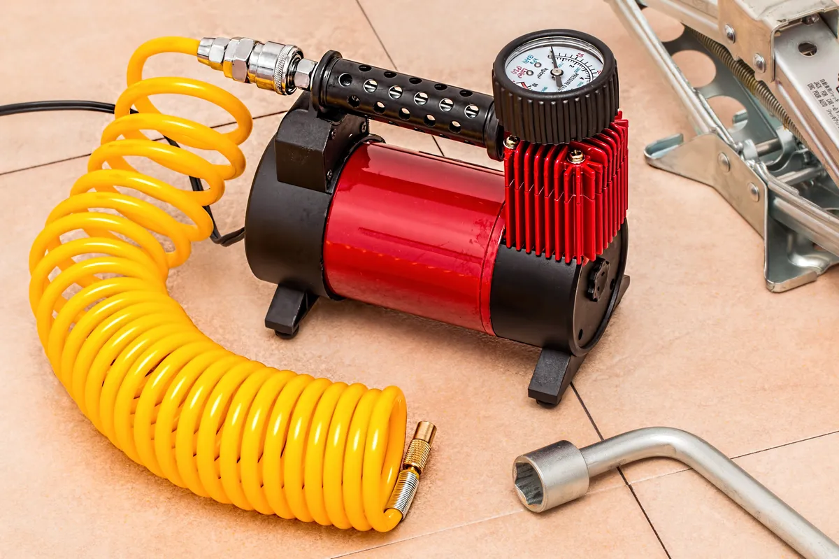 A compressor-driven tyre pump, whose built-in gauge is measured while running