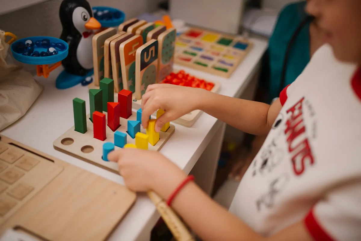 Child engaged in a colorful hands-on building and learning activity at a table