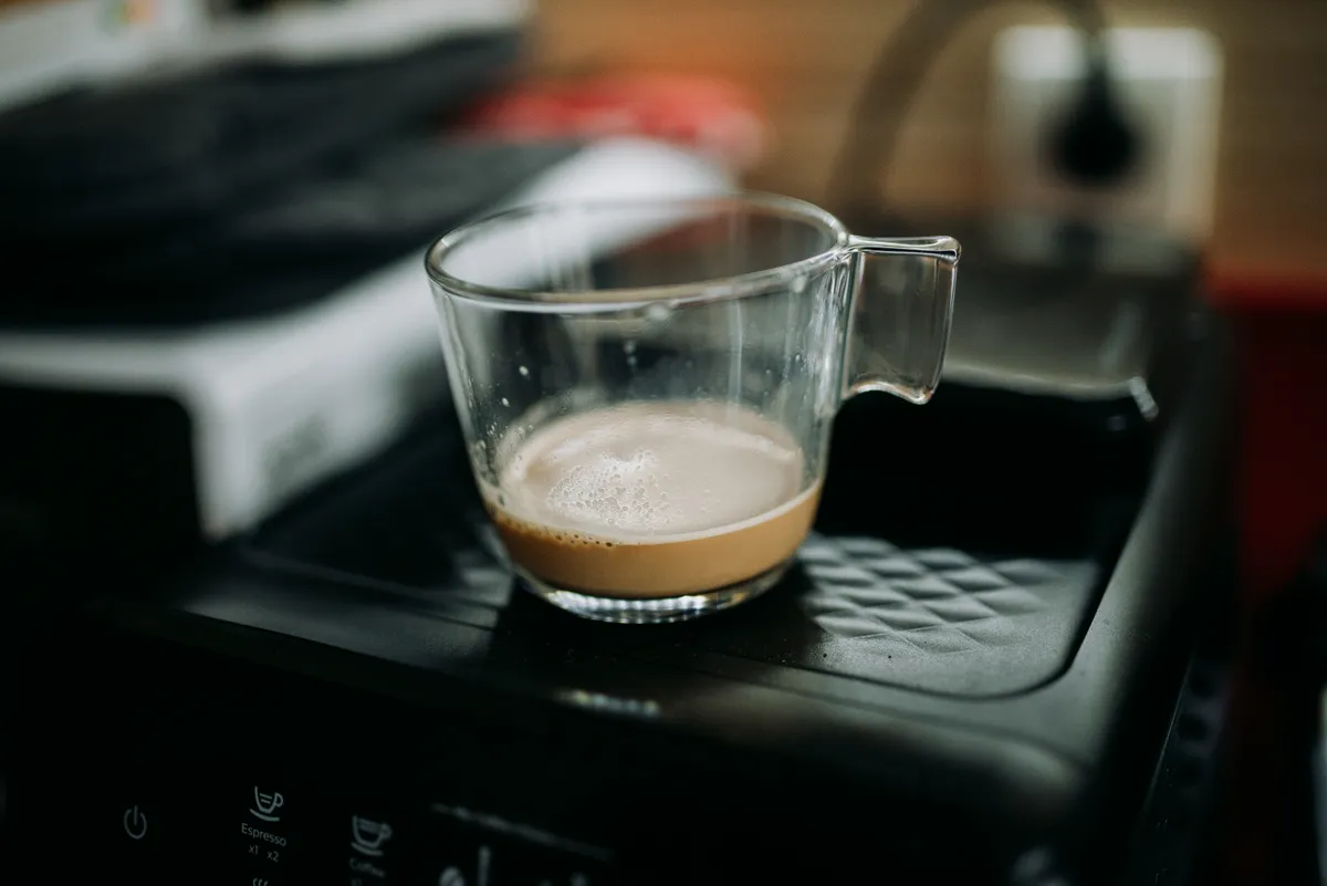 A coffee cup resting on a warming appliance base, illustrating the concept of a heated charging coaster